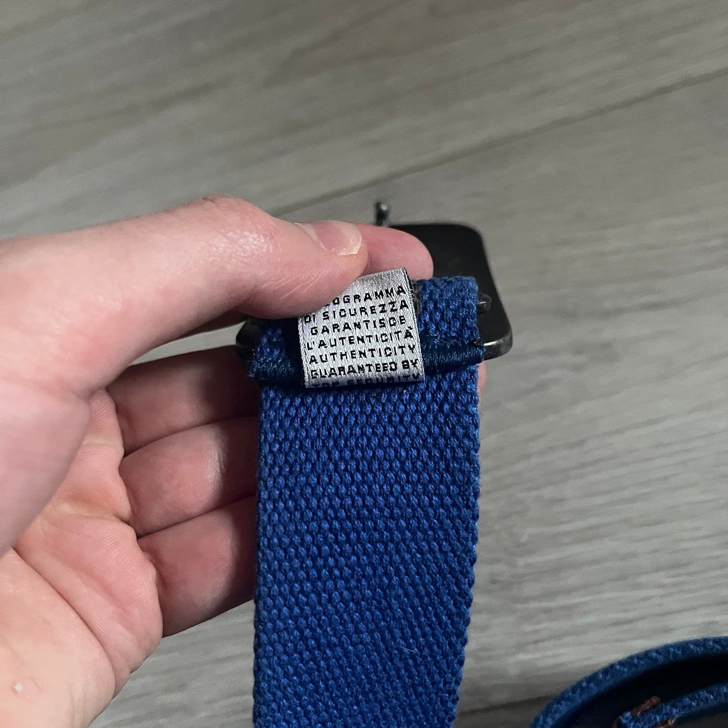 Dolce &amp; Gabbana “High Spirits” Fabric Belt in blue with a brown/gray central stripe and enamel-finished metal buckle. The buckle features vintage iconography and “High Spirits” lettering in vivid orange/red and navy tones. A rare 2000s-era Dolce &amp; Gabbana belt showcasing the brand’s early denim aesthetic.