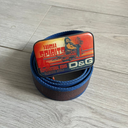 Dolce &amp; Gabbana “High Spirits” Fabric Belt in blue with a brown central stripe and enamel-finished metal buckle. The buckle features vintage iconography and “High Spirits” lettering in vivid orange/red and navy tones. A rare 2000s-era Dolce &amp; Gabbana belt showcasing the brand’s early denim aesthetic.
