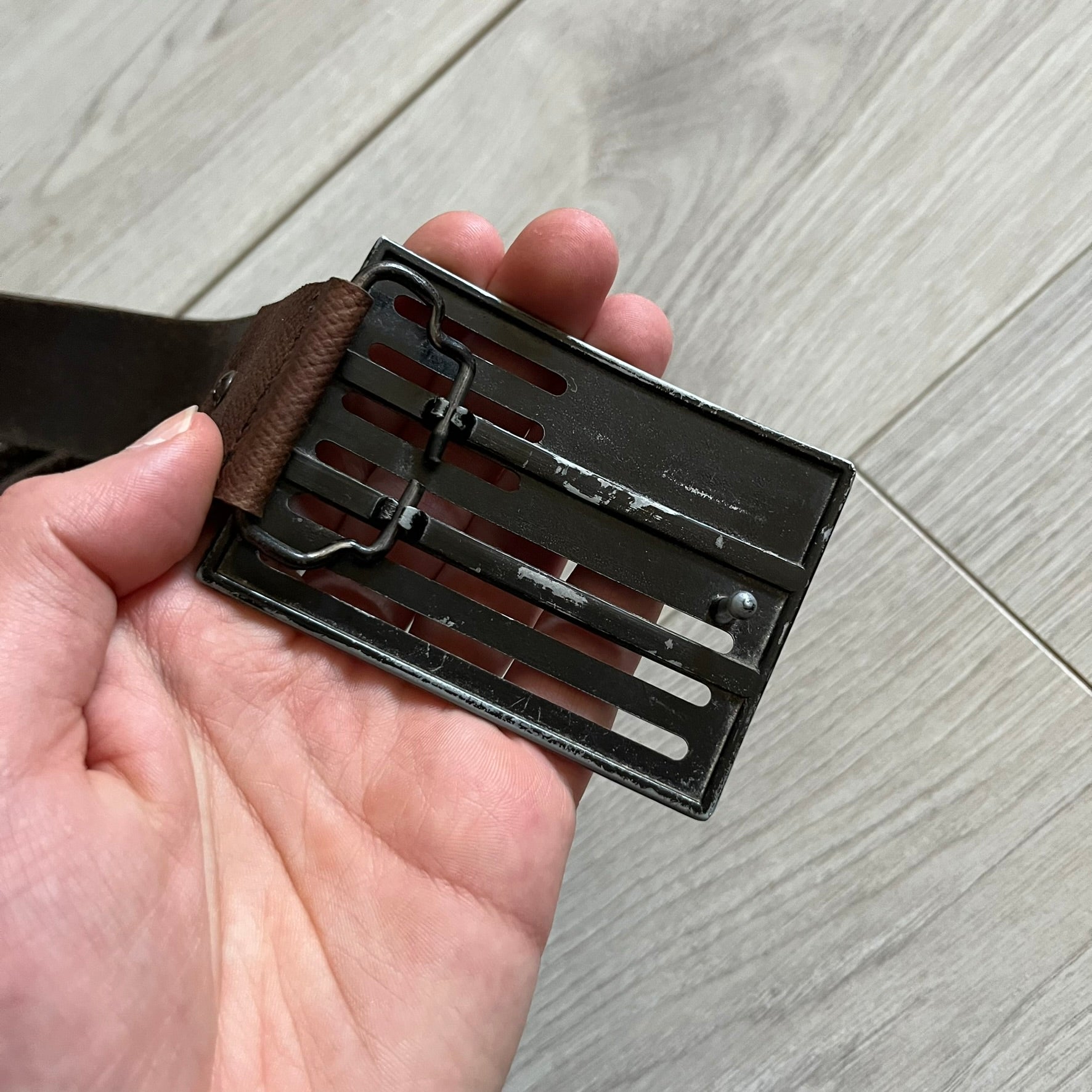 Dolce &amp; Gabbana USA Flag Leather Belt crafted from brown leather with concave, sunken Dolce &amp; Gabbana and D&amp;G text detailing along the strap. The metal buckle is designed in a flag-inspired layout, featuring six horizontal cut-out lines and D&amp;G Dolce &amp; Gabbana text in the upper-left corner in place of traditional stars. The belt shows visible wear consistent with age, giving it a heavily worn, vintage finish.