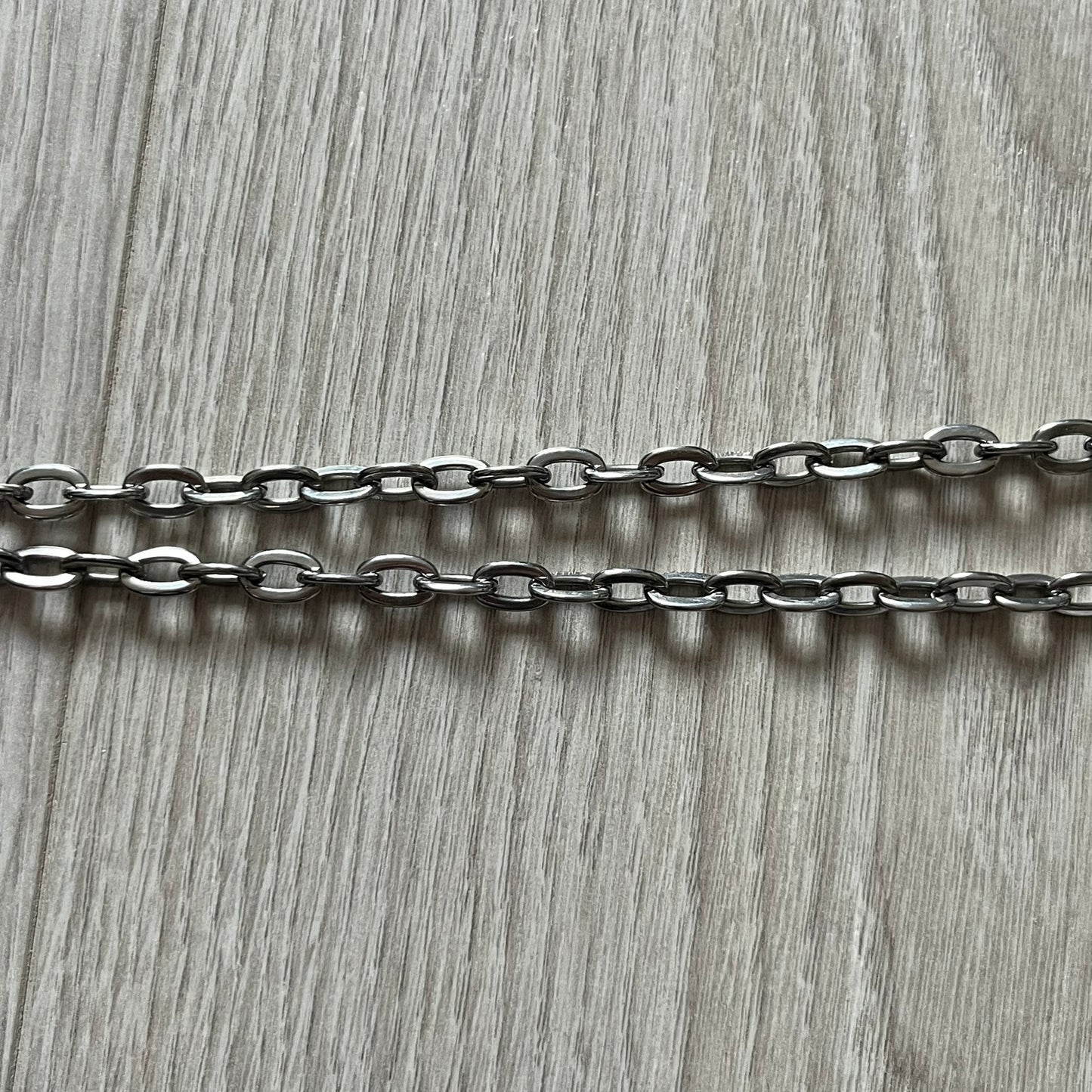 Dolce & Gabbana 'Unclassifiable' Dog Tag Necklace in stainless steel with a silver cable chain and lobster clasp. Features a thick dog tag with four visible screws on the front and engraved D& G logo with “Unclassifiable” diagonally beneath.