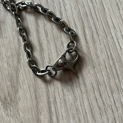 Dolce & Gabbana 'Unclassifiable' Dog Tag Necklace in stainless steel with a silver cable chain and lobster clasp. Features a thick dog tag with four visible screws on the front and engraved D& G logo with “Unclassifiable” diagonally beneath.