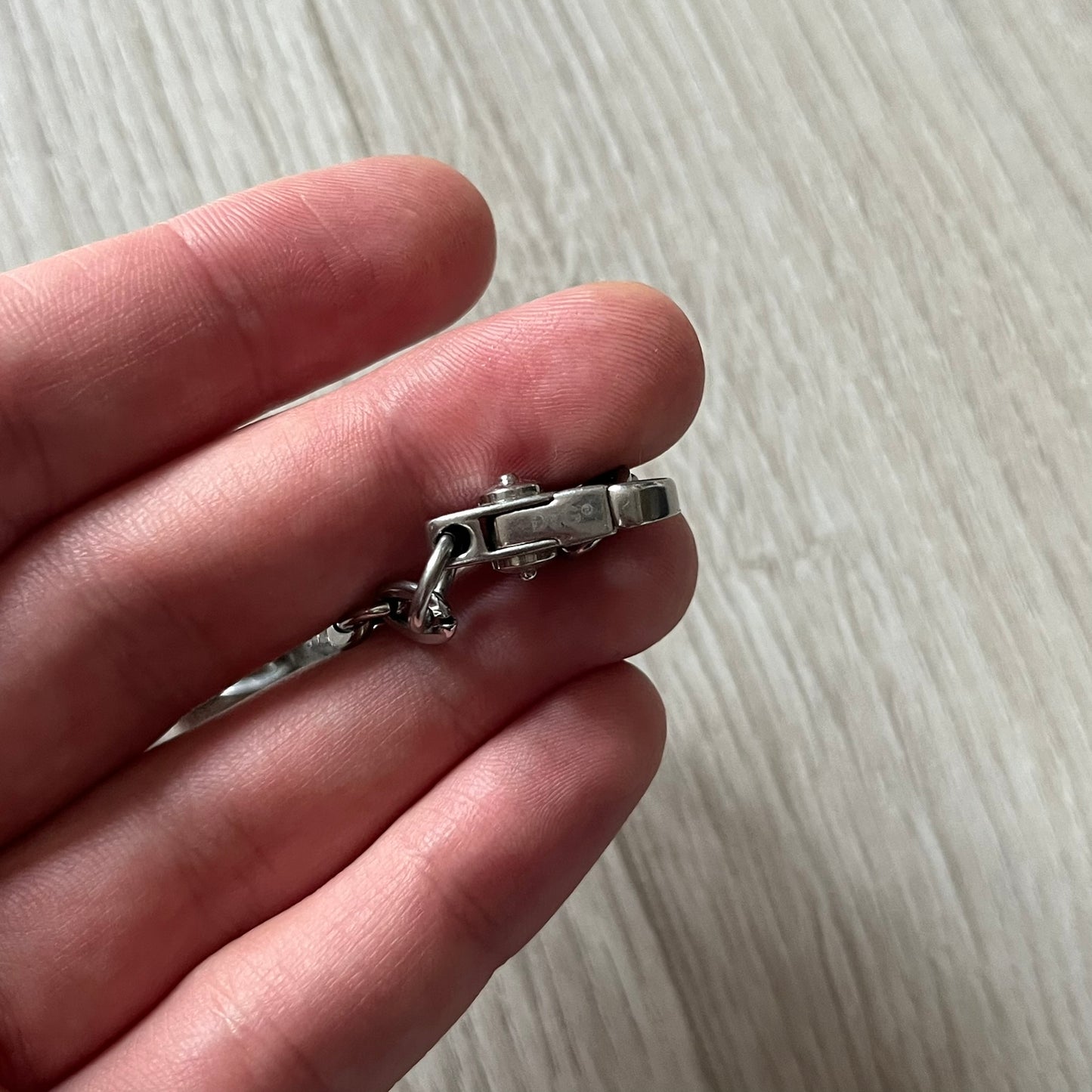 Dolce & Gabbana 'Unclassifiable' Dog Tag Necklace in stainless steel with a silver cable chain and lobster clasp. Features a thick dog tag with four visible screws on the front and engraved D& G logo with “Unclassifiable” diagonally beneath.