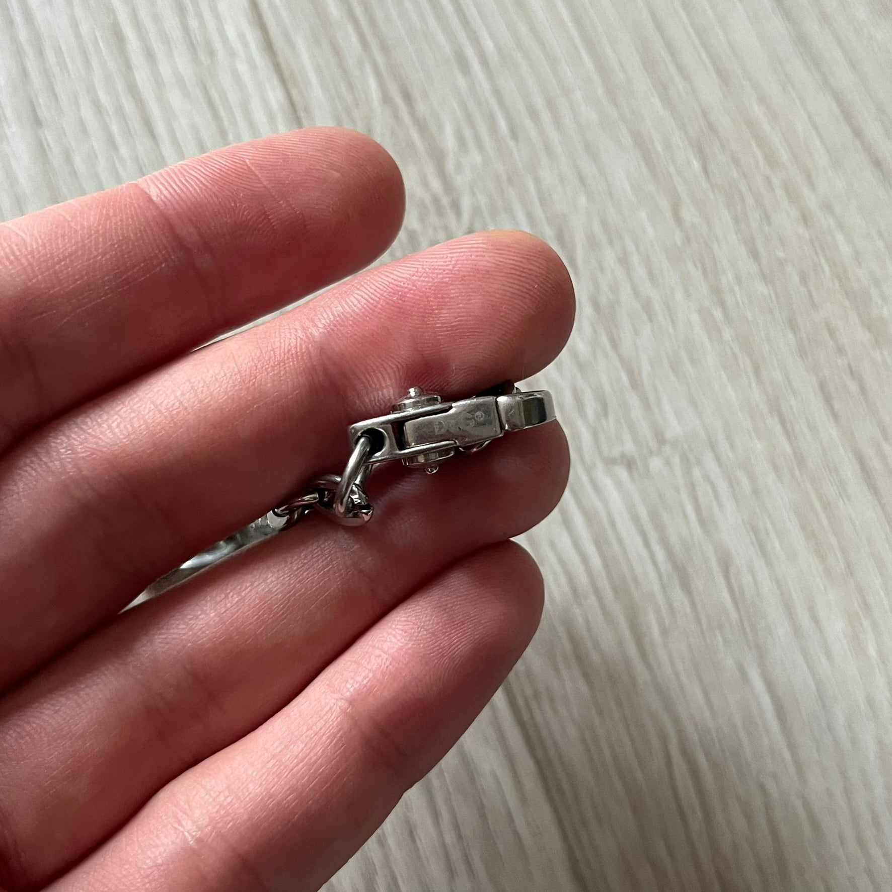 Dolce & Gabbana 'Unclassifiable' Dog Tag Necklace in stainless steel with a silver cable chain and lobster clasp. Features a thick dog tag with four visible screws on the front and engraved D& G logo with “Unclassifiable” diagonally beneath.