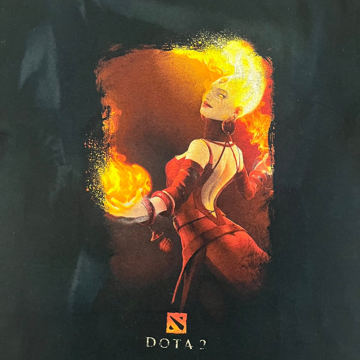 Dota 2 promo T-shirt from 2013 featuring a large graphic of Lina the Slayer with the official Dota 2 logo beneath. Printed on a Gildan Heavy Cotton blank, it includes a small Nvidia logo on the back as part of the original PC gaming promotion. A rare piece of early Dota 2 merchandise.&nbsp;