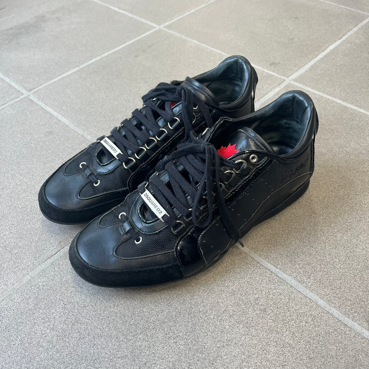 Dsquared2 2010's Multi Fabric Legendary Sneakers are constructed from tonal velvet, patent leather, metal eyelets and a woven rubber sole. They feature a red embroidered Canadian leaf on the tongue, a metal Dsquared2 plaque at the base of the laces, and an embroidered black Dsquared2 logo.