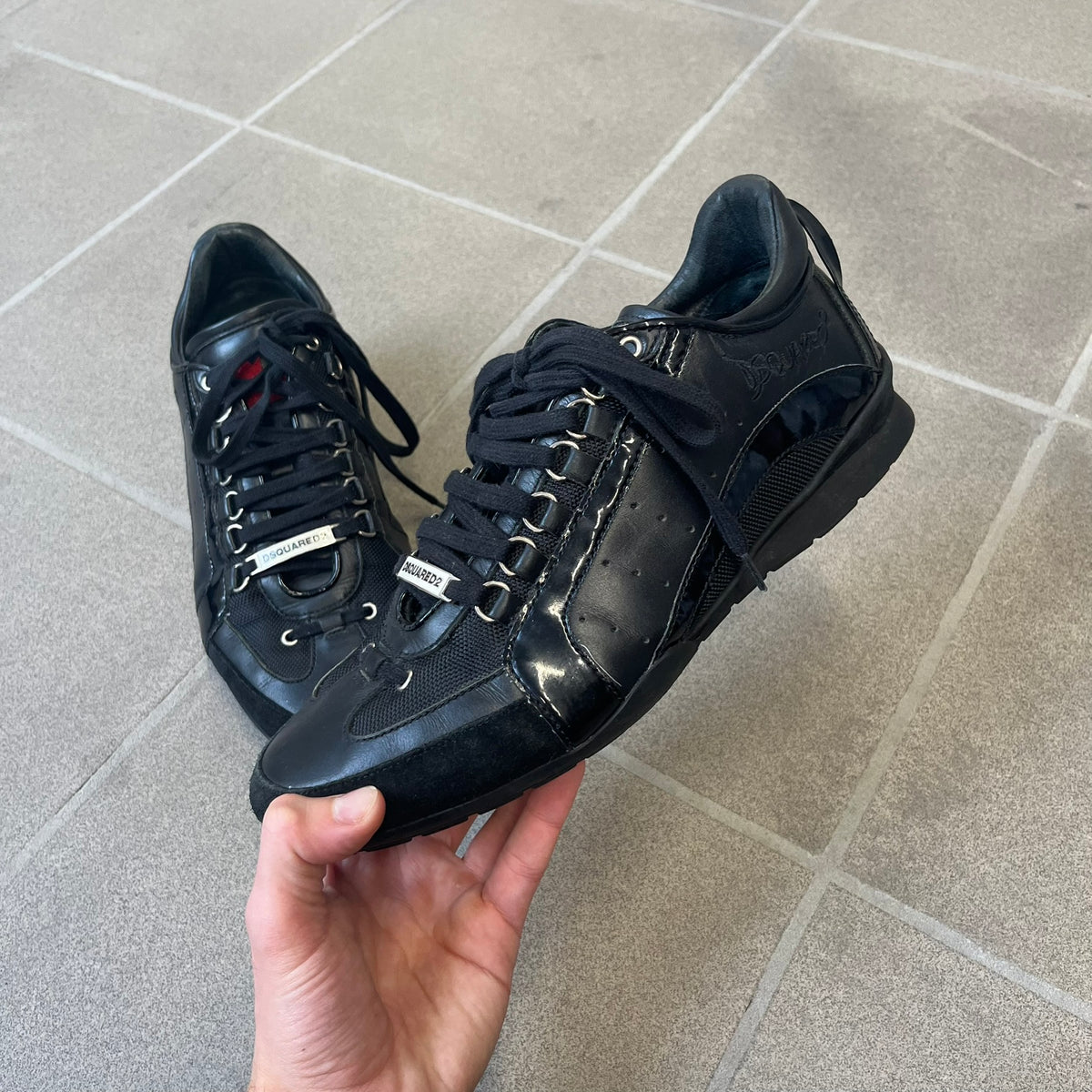 Dsquared2 2010's Multi Fabric Legendary Sneakers are constructed from tonal velvet, patent leather, metal eyelets and a woven rubber sole. They feature a red embroidered Canadian leaf on the tongue, a metal Dsquared2 plaque at the base of the laces, and an embroidered black Dsquared2 logo.