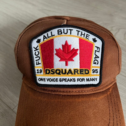 Brown cap with a patch featuring a Canadian flag and text on a light wooden surface