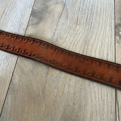 Dsquared2 Big Navy Plaque Leather Belt is a leather belt featuring a large oval metal buckle with a silver-tone frame and navy enamel center. The buckle displays DSQUARED2 text in the middle, while the strap includes stamped branding and product details. Made from brown leather, the belt is size small.