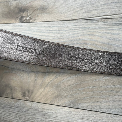 Dsquared2 Big Red Plaque Leather Belt is a leather belt featuring a large oval metal buckle with a silver-tone frame and red metallic center. The buckle displays DSQUARED2 text in the middle, while the strap includes stamped branding and product details. Made from brown leather, the belt is size small.