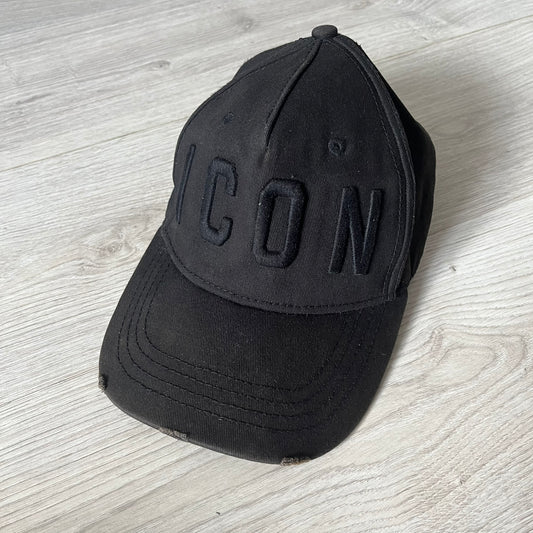 Black cap with 'ICON' text on a light wooden surface