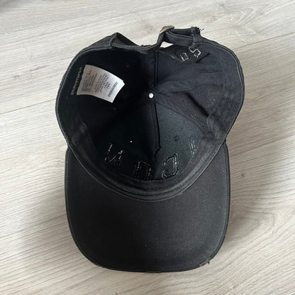 Black cap with brand logo on a light wooden surface