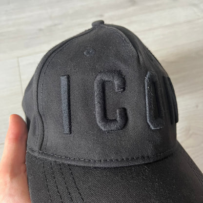 Black cap with 'IC' logo held by a hand on a light gray background