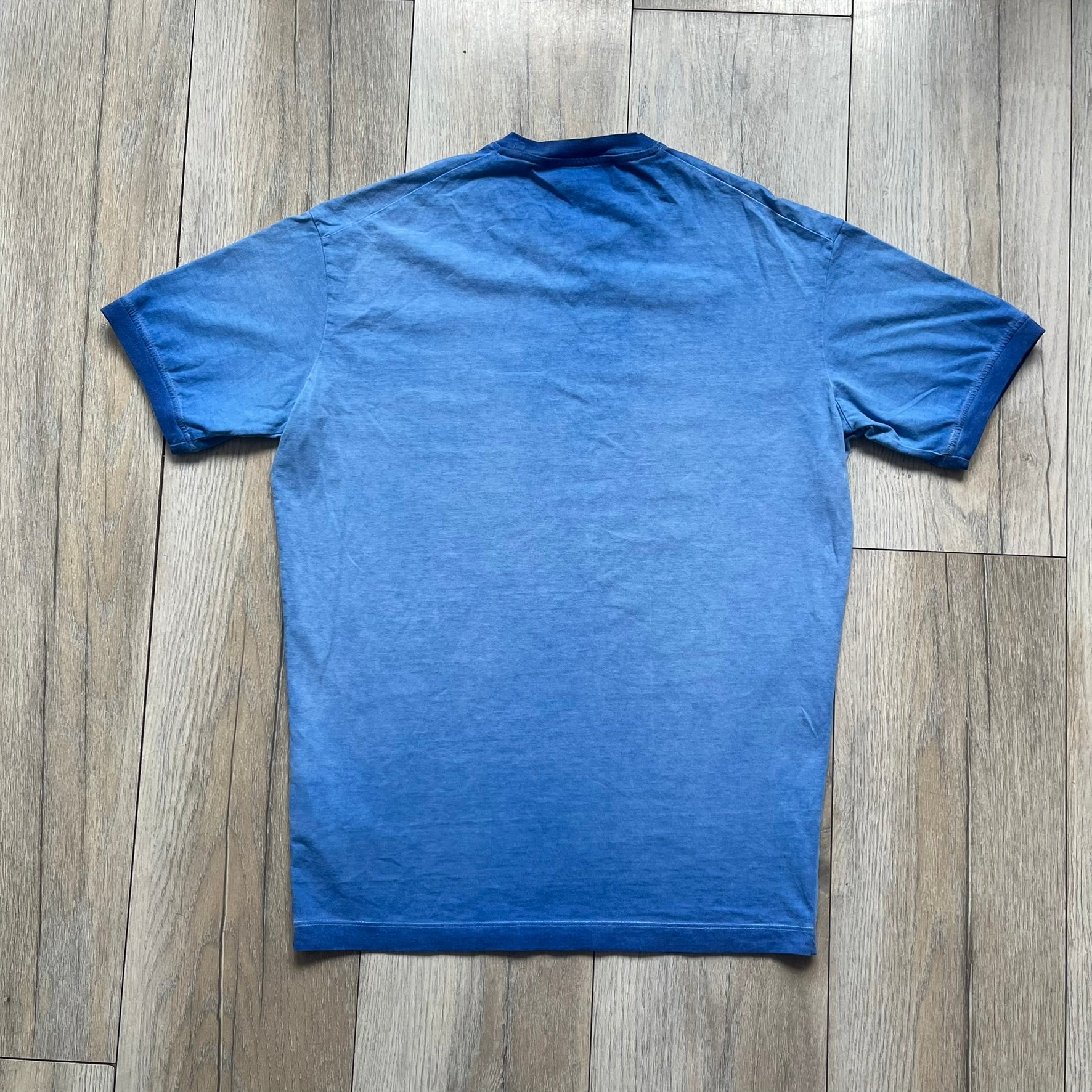 Dsquared2 Blue Rebel Monkey T-Shirt from the Spring/Summer 2015 collection. Crafted in Italy from cotton, the tee features a washed blue finish with darker tonal hems and a lighter faded center. The front displays a large stylized monkey graphic in black with light blue, with text reading “Monkey Me… Dsquared2 Motherfuc…” incorporated into the design.