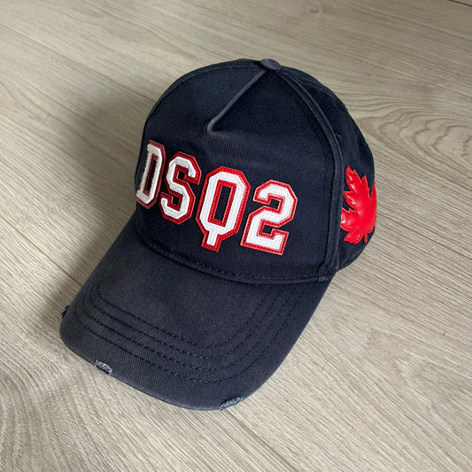 Black cap with 'DSQ2' and red maple leaf logo on a wooden surface