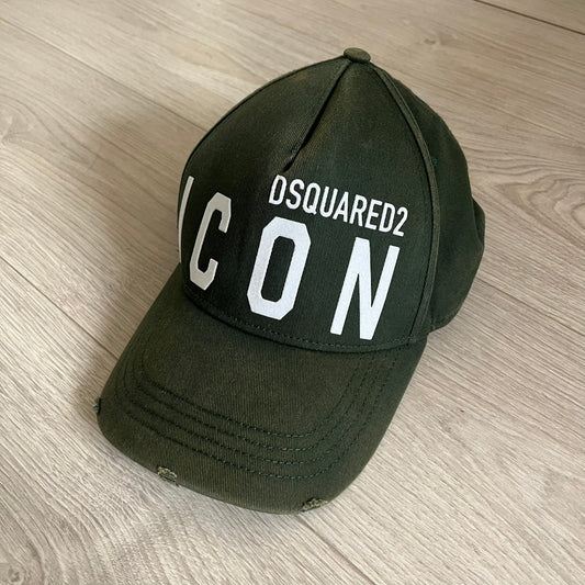 Green cap with 'DSQUARED2 ICON' text on a wooden surface