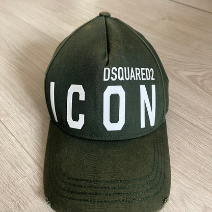 Green cap with 'DSQUARED2 ICON' text on a wooden surface
