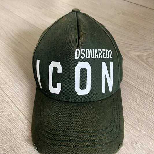 Green cap with 'DSQUARED2 ICON' text on a wooden surface