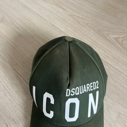 Green cap with 'DSQUARED2 ICON' text on a wooden surface