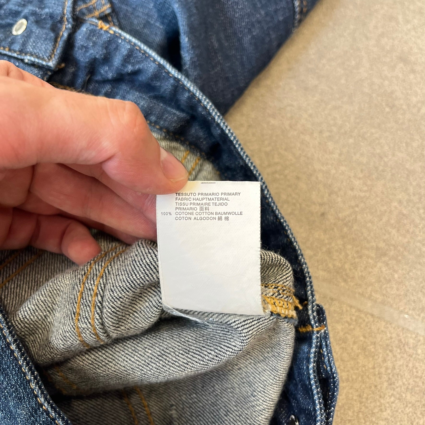 Dsquared2 SS15 Rebel Monkey Denim Jacket features a denim construction with two chest pockets on the front. The back has a large Rebel Monkey graphic in white, blue, and red, with black Dsquared2 text above it. The jacket includes intentional tears, paint splatters, and other distressed details. Made in Italy as part of the Dsquared2 collaboration with Basquiat.
