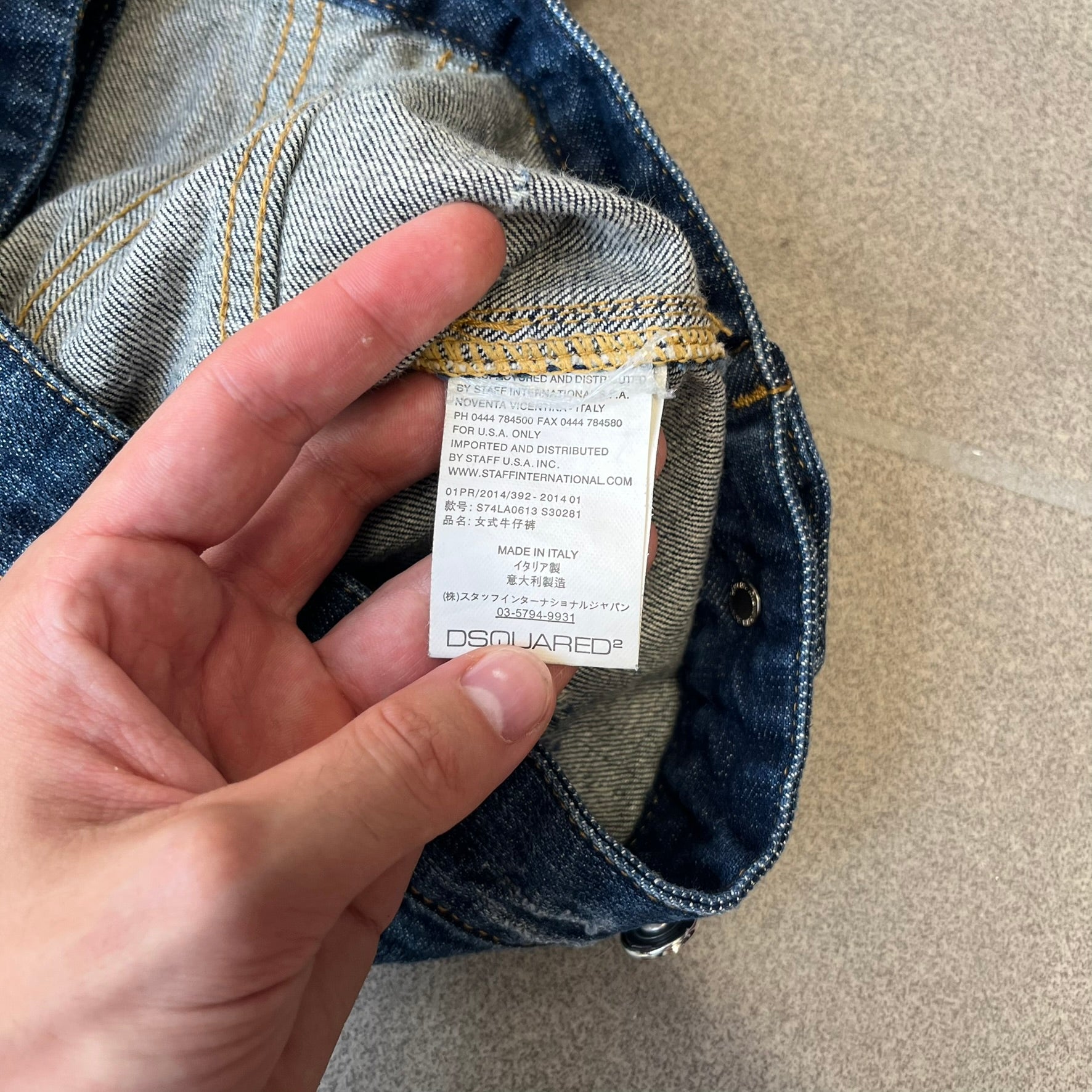 Dsquared2 SS15 Rebel Monkey Denim Jacket features a denim construction with two chest pockets on the front. The back has a large Rebel Monkey graphic in white, blue, and red, with black Dsquared2 text above it. The jacket includes intentional tears, paint splatters, and other distressed details. Made in Italy as part of the Dsquared2 collaboration with Basquiat.
