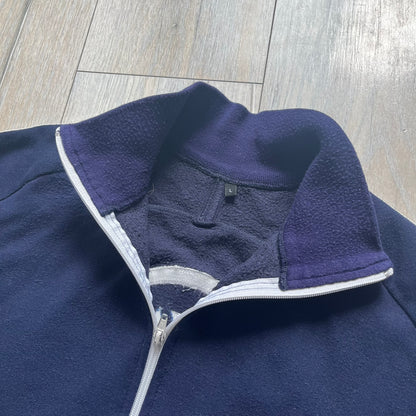EA Sports 2000s Track Jacket is a navy track jacket with a full white zip closure, white two stripes running down both sleeves, and a fold-down collar. The back features a large stitched EA GAMES circular logo patch.&nbsp;