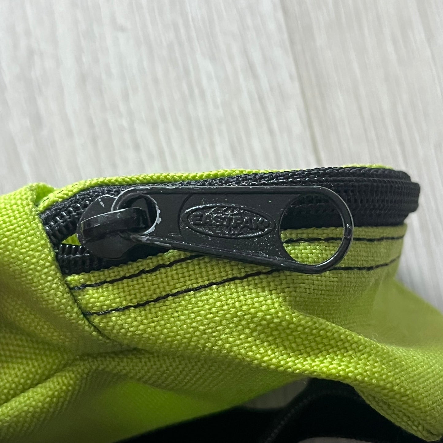Eastpak’s Mini Green Backpack is a collectible-sized accessory with elastic pack straps. While it can be used as a tiny bag, it’s more often seen as a novelty piece or keychain. A playful twist on the brand’s iconic design.