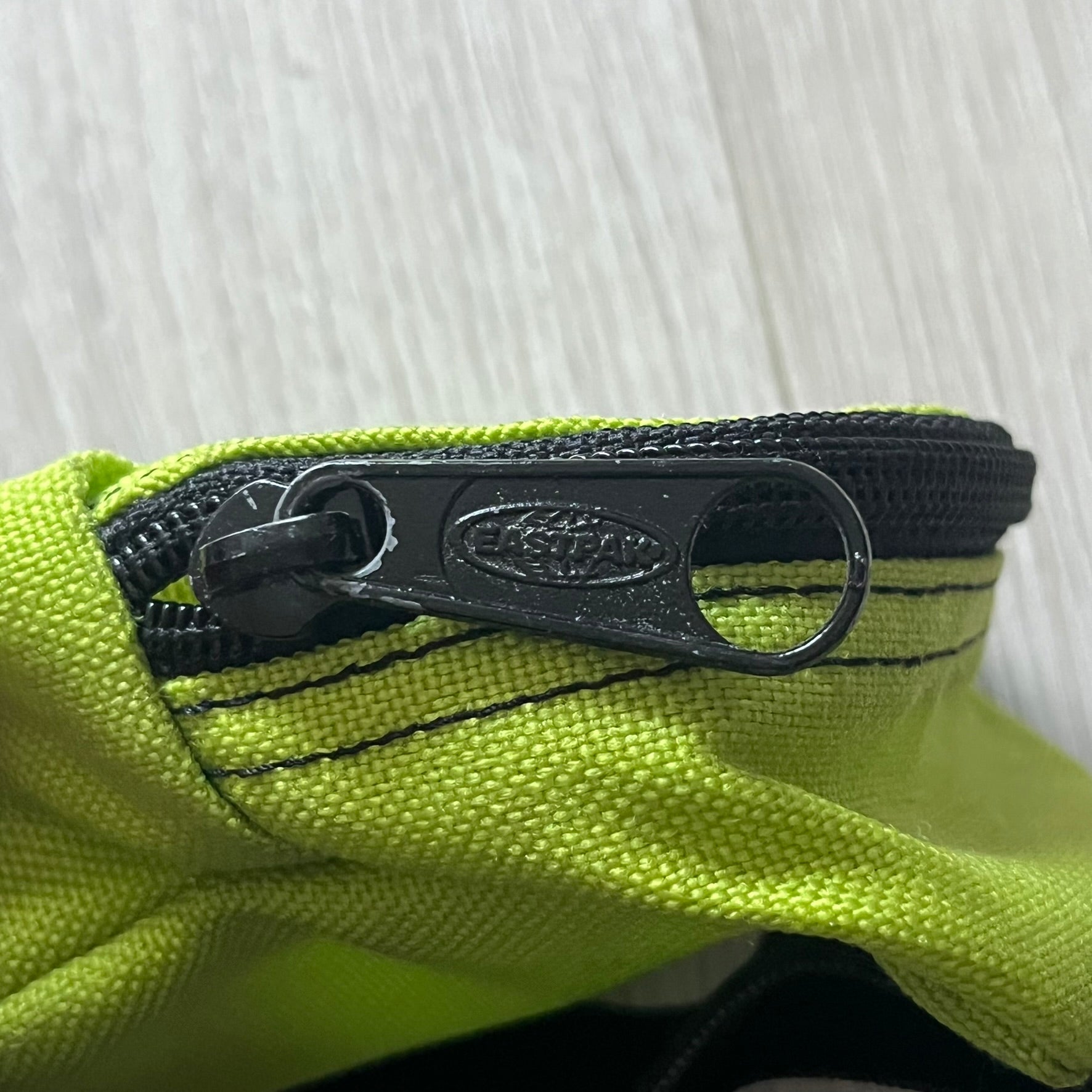 Eastpak’s Mini Green Backpack is a collectible-sized accessory with elastic pack straps. While it can be used as a tiny bag, it’s more often seen as a novelty piece or keychain. A playful twist on the brand’s iconic design.