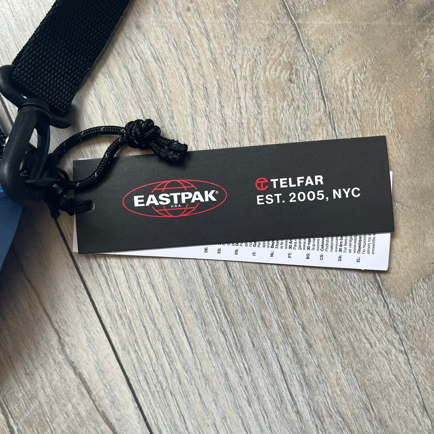 Eastpak x Telfar Circle Blue Shoulder Bag is crafted from polyester tactical canvas in a Cerulean colorway with black-tone hardware. The bag features woven hand straps, a removable and adjustable padded shoulder strap for crossbody or waist wear, and an embossed Telfar logo on the exterior. Released for SS24 on 06/14/2024 with a retail price of $110, the interior includes zip pockets and mesh compartments for organized storage.