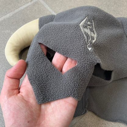 The Elder Scrolls V: Skyrim 2011 Dragonborn Helmet Hat is a grey fleece helmet-style beanie with large cream-colored curved horns and eye openings. The front features an embroidered light grey Skyrim dragon emblem on the forehead. Originally distributed by Bethesda as a promotional item at PAX Prime in 2011.
