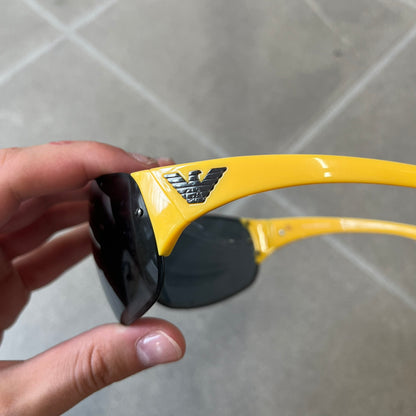 Emporio Armani 2000's Shield Yellow Sunglasses feature a black shield-style front with a single continuous lens and yellow temples. The temples have black Emporio Armani eagle logos, with model EA 9242/S SVG95. Made in Italy and comes with the original red case.
