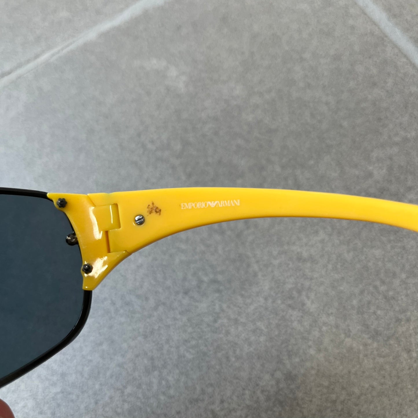 Emporio Armani 2000's Shield Yellow Sunglasses feature a black shield-style front with a single continuous lens and yellow temples. The temples have black Emporio Armani eagle logos, with model EA 9242/S SVG95. Made in Italy and comes with the original red case.
