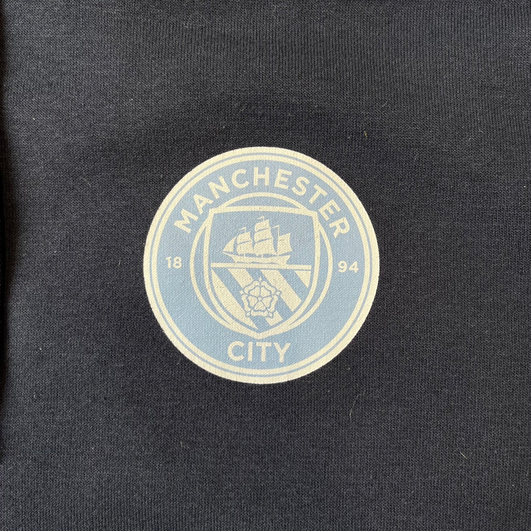 FaZe Clan x Manchester City 2019 Hoodie is an official collaboration combining esports and football culture. Made in Portugal from a 60% cotton and 40% polyester blend, it features the Manchester City club crest on the right chest and the FaZe Clan logo on the left. The back is finished with a large "FAZE CITY" graphic, with ribbed cuffs, a ribbed hem, and a kangaroo pocket.