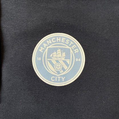 FaZe Clan x Manchester City 2019 Hoodie is an official collaboration combining esports and football culture. Made in Portugal from a 60% cotton and 40% polyester blend, it features the Manchester City club crest on the right chest and the FaZe Clan logo on the left. The back is finished with a large "FAZE CITY" graphic, with ribbed cuffs, a ribbed hem, and a kangaroo pocket.