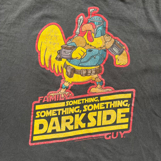 Family Guy 2009 Star Wars "Something Darkside" Tee is a washed black T-shirt made on a Delta Pro Weight blank. The front features Ernie the Giant Chicken dressed as Boba Fett above yellow Star Wars-style “Something, Something, Something, Dark Side” text with a red Family Guy outline surrounding the graphic. Small 2009 licensing details are printed below the design.