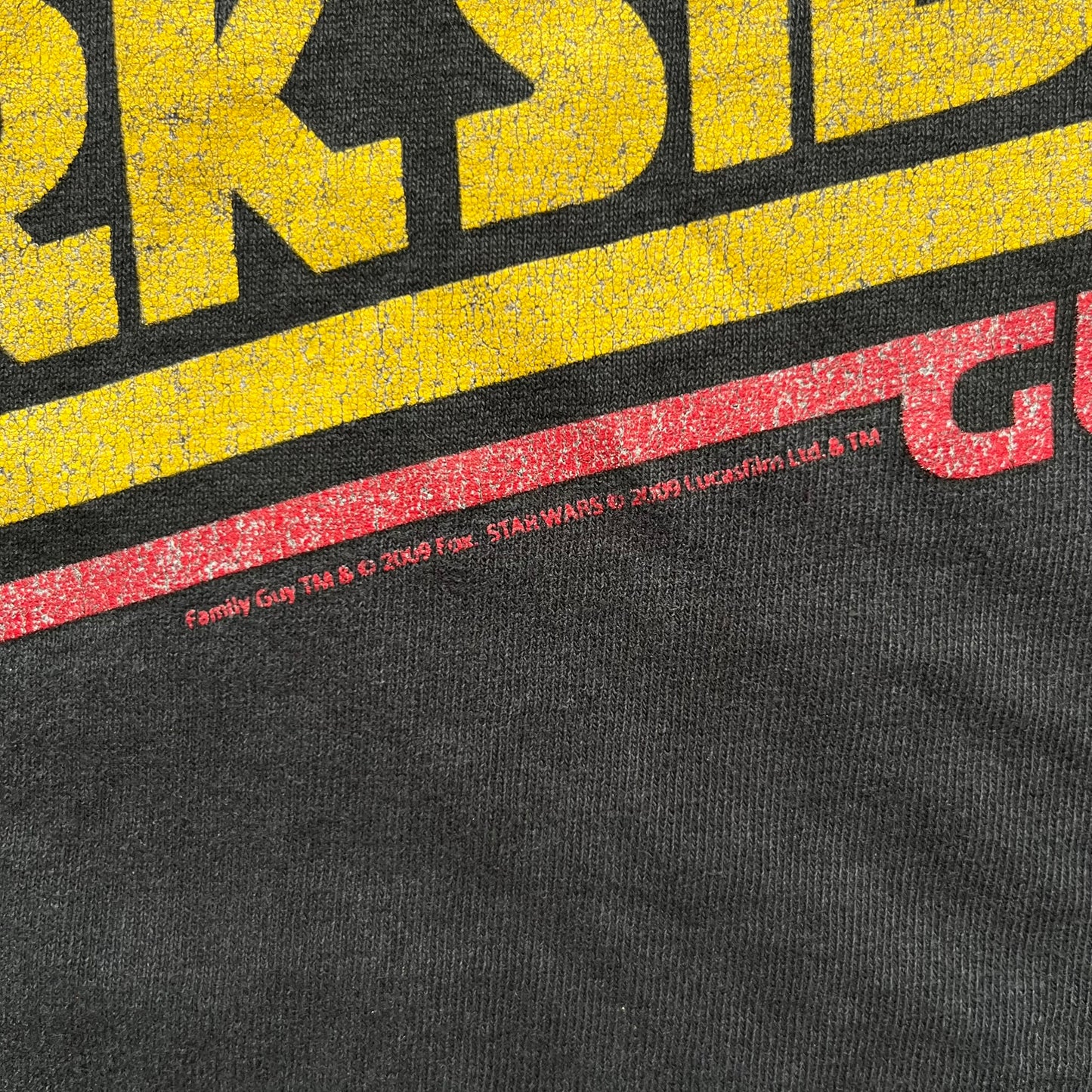 Family Guy 2009 Star Wars "Something Darkside" Tee is a washed black T-shirt made on a Delta Pro Weight blank. The front features Ernie the Giant Chicken dressed as Boba Fett above yellow Star Wars-style “Something, Something, Something, Dark Side” text with a red Family Guy outline surrounding the graphic. Small 2009 licensing details are printed below the design.