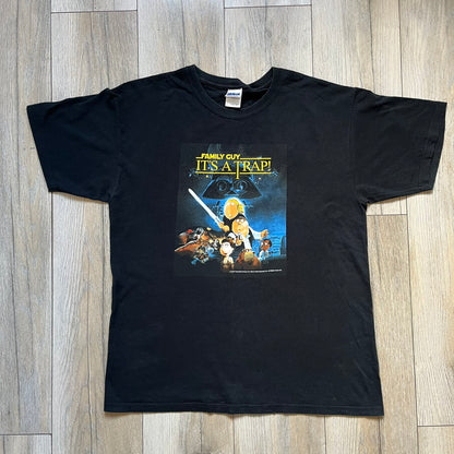 Family Guy Star Wars 2010 “It’s a Trap!” Tee is a black short-sleeve T-shirt made on a Gildan blank. The front features a large graphic in Family Guy’s Star Wars parody style with yellow “It’s a Trap!” text, and small 2010 Century Fox licensing at the bottom. This shirt was released in 2010 as official Family Guy merchandise