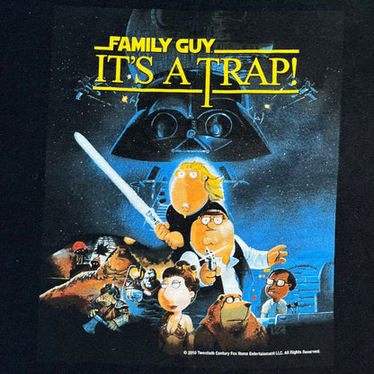 Family Guy Star Wars 2010 “It’s a Trap!” Tee is a black short-sleeve T-shirt made on a Gildan blank. The front features a large graphic in Family Guy’s Star Wars parody style with yellow “It’s a Trap!” text, and small 2010 Century Fox licensing at the bottom. This shirt was released in 2010 as official Family Guy merchandise