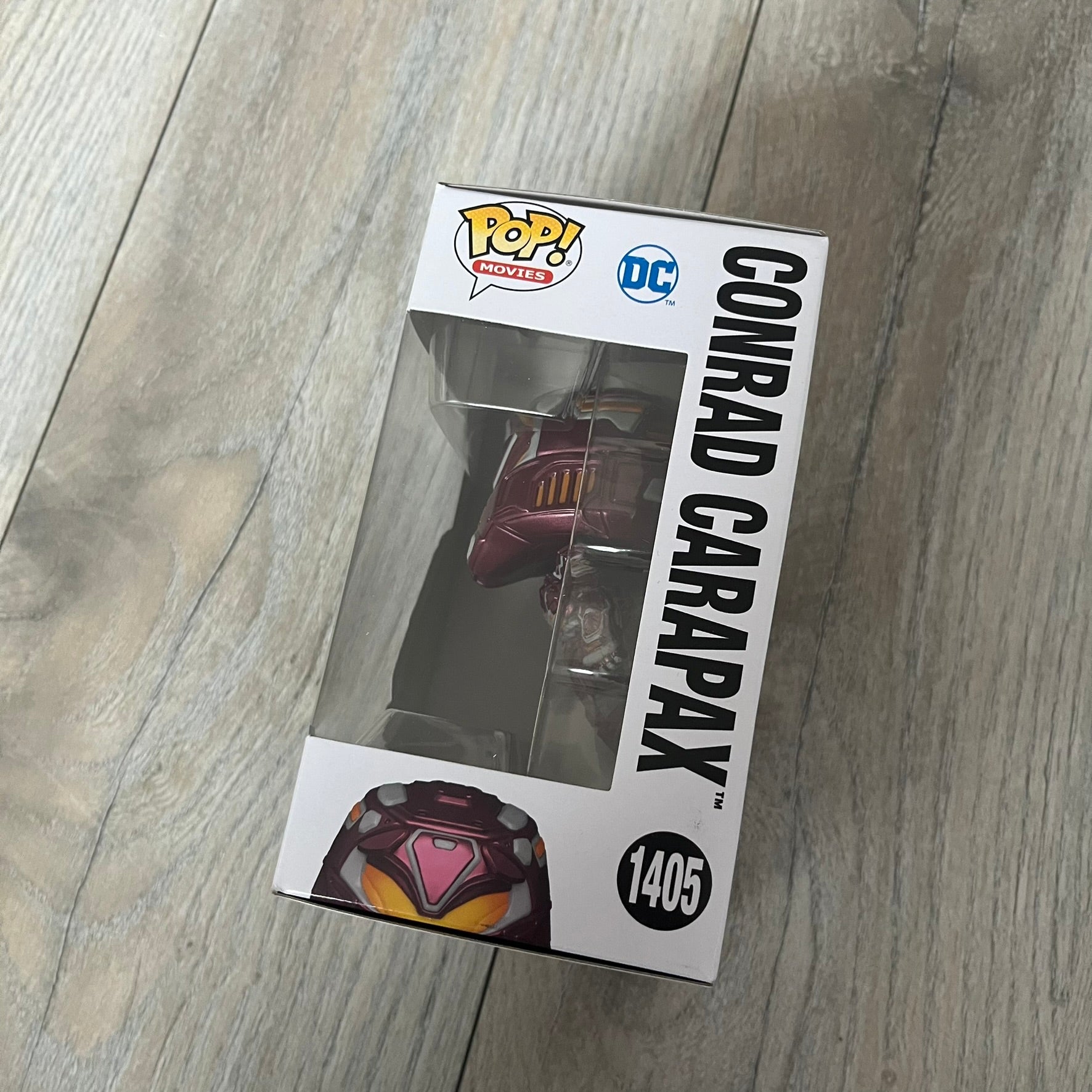 Funko Pop! Movies: Blue Beetle Conrad Carapax #1405 is a 2023 vinyl figure from the DC Blue Beetle (2023) movie line. It depicts Conrad Carapax in his armored design with a color scheme of deep maroon, bright yellow, and metallic accents. The figure is part of the standard 4-inch POP! vinyl series and features detailed sculpting based on the film character