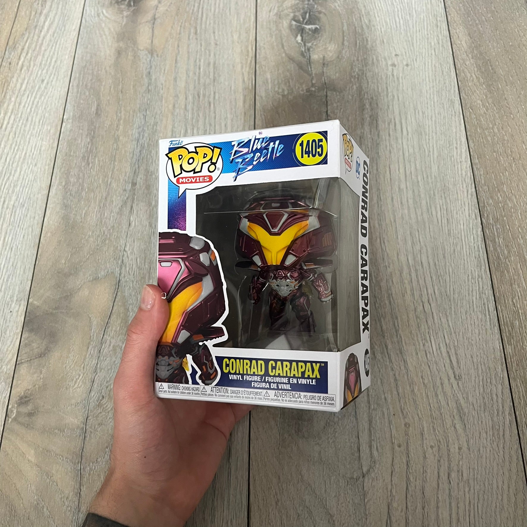 Funko Pop! Movies: Blue Beetle Conrad Carapax #1405 is a 2023 vinyl figure from the DC Blue Beetle (2023) movie line. It depicts Conrad Carapax in his armored design with a color scheme of deep maroon, bright yellow, and metallic accents. The figure is part of the standard 4-inch POP! vinyl series and features detailed sculpting based on the film character