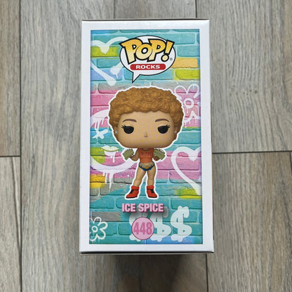 Funko Pop! Rocks Ice Spice (Classic Y2K!) #448 Figure is a vinyl collectible released in 2025 as part of the Funko Pop! Rocks music series. The figure represents Ice Spice wearing her orange Y2K! era outfit and holding stacks of money in both hands. The figure follows the standard Funko Pop! stylized design and was released on May 8, 2025 under the Pop! Rocks line.