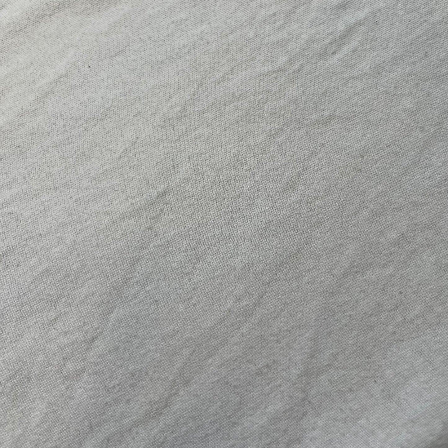 GTA V Los Santos 2013 White Tee features a white design with a large “Los Santos” graphic on the front in a tattoo-style font. The lower front includes a GTA V tag detail, while the neck tag features the Rockstar logo. The back has a small black Rockstar logo.
