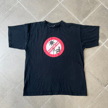 GamersWear 2010's Fuck The Sun Black Tee features a black 100% cotton T-shirt with a road sign-style graphic on the front. The graphic shows a black figure sitting at a computer beneath a black sun, surrounded by a white background and red outline. A red line crosses the design with white “Fuck The Sun” text, along with small red GamersWear branding.
