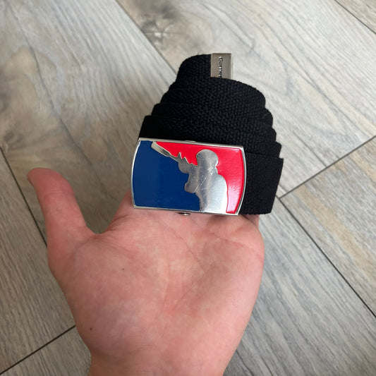 Gamerswear Counter-Strike 2016 Black Belt is a black cotton belt with an adjustable fit and a metal tip featuring a cutout Gamerswear logo. The buckle showcases an armed character in a silver finish, framed by blue enamel on the left side and red enamel on the right. The central figure is highlighted with a raised silver design and matching silver border detailing.
