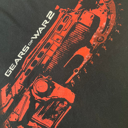 Gears of War 2 2008 Red Lancer Tee is a black, 100% cotton T-shirt featuring a large red Lancer graphic on the front alongside small white "Gears of War 2" text. The upper back displays the GOW2 skull logo with 2008 licensing below.