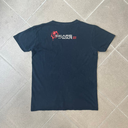 Gears of War 2 2008 Red Lancer Tee is a black, 100% cotton T-shirt featuring a large red Lancer graphic on the front alongside small white "Gears of War 2" text. The upper back displays the GOW2 skull logo with 2008 licensing below.