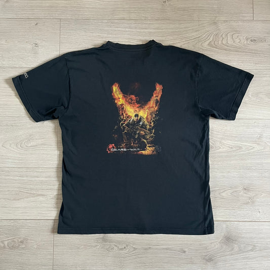 Black Gears of War Tee for Xbox 360 with a small red skull front logo on the chest and white Xbox 360 logo on the sleeve. The back features a full-color cover graphic with Marcus Fenix and branding of the game and Epic Games. Xbox tagged on the side, wash tag is faded.