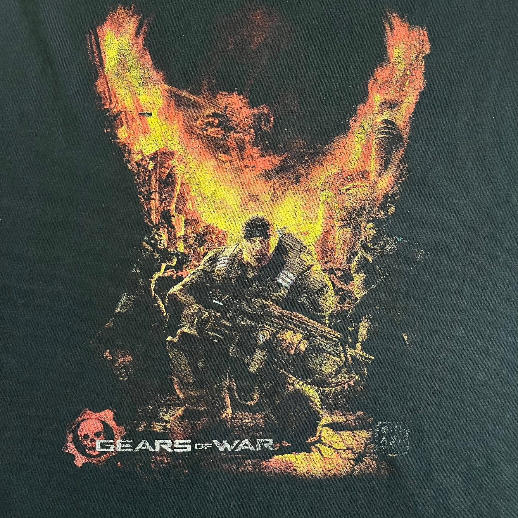 Black Gears of War Tee for Xbox 360 with a small red skull front logo on the chest and white Xbox 360 logo on the sleeve. The back features a full-color cover graphic with Marcus Fenix and branding of the game and Epic Games. Xbox tagged on the side, wash tag is faded.