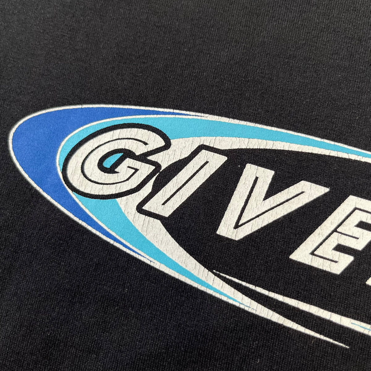 Givenchy AW18 Aquarius Black Tee is a black, slim-fit T-shirt made from 100% cotton, featuring white "GIVENCHY" text on the front alongside a blue half-moon-shaped graphics. The back displays an Aquarius-inspired design in white, gray, and blue, depicting a fountain with a large bird, a cube built from repeated Givenchy logos, and a Givenchy signature.