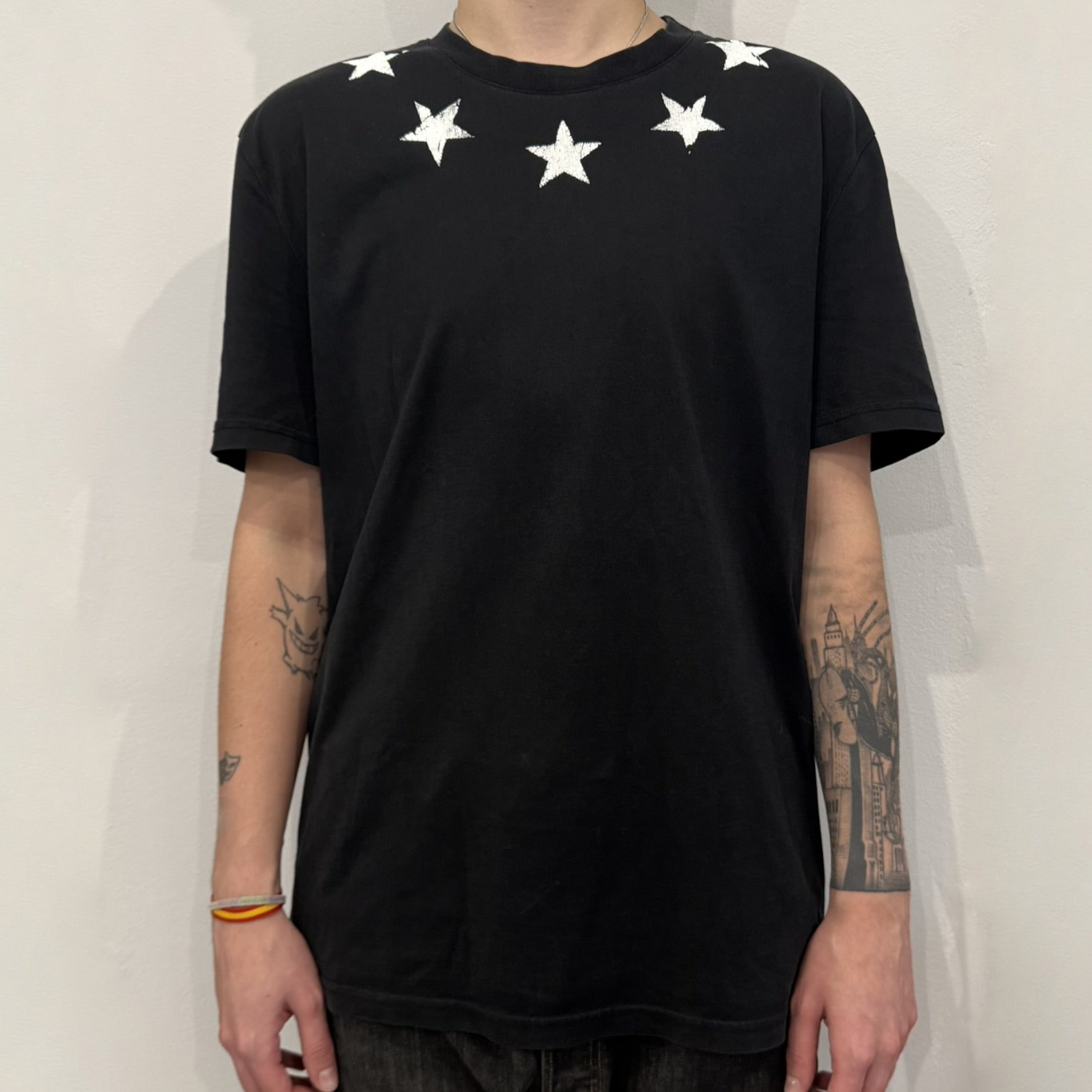 This Givenchy Distressed Black Stars Tee features the label’s iconic star motif from the FW18 season, with five stars across the front collar and four at the back. Crafted in Portugal from 100% cotton, it offers a slim fit and a soft, ribbed crewneck finish. A sought-after Givenchy stars shirt, and yes the distressed stars are intentional, not due to wear.