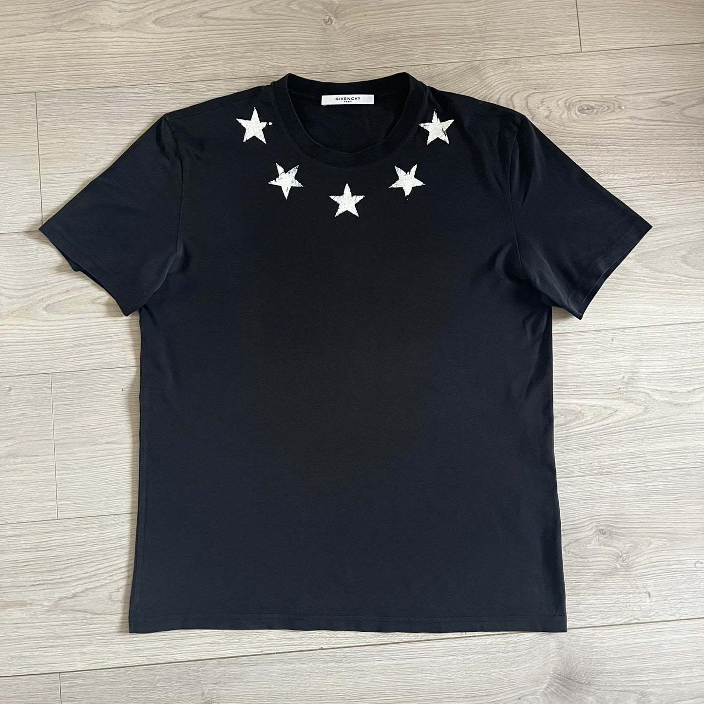 This Givenchy Distressed Black Stars Tee features the label’s iconic star motif from the FW18 season, with five stars across the front collar and four at the back. Crafted in Portugal from 100% cotton, it offers a slim fit and a soft, ribbed crewneck finish. A sought-after Givenchy stars shirt, and yes the distressed stars are intentional, not due to wear.